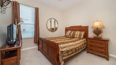 a bedroom with a bed and a dresser and a tv at Windsor Palms Resort Vacation Home in Kissimmee