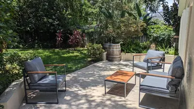 three chairs and a coffee table on a patio at Modern 3BR Home 10 Min from MCO in Orlando