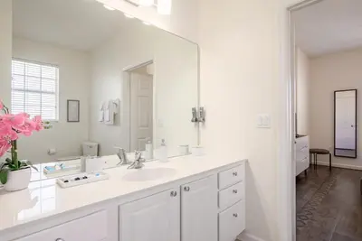 a white bathroom with a sink and a mirror at 4862 Cayview Avenue 208 in Orlando