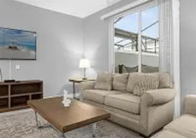 a living room with a couch and a table at 4243 PA - Storey Lake Escape 4BR Pool Home Near Disney in Kissimmee