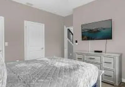 a bedroom with a bed and a dresser with a television at 4243 PA - Storey Lake Escape 4BR Pool Home Near Disney in Kissimmee
