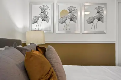 three prints of a plant on a wall above a bed at 2900SS SL Family Lakeview Escape Disney-Themed Fun 8 Mins to Parks in Kissimmee