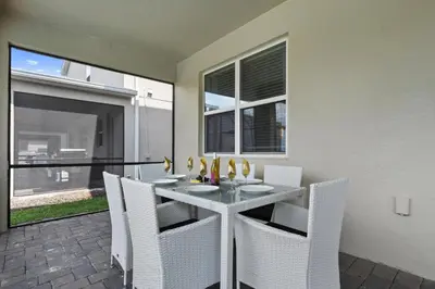 a dining room with a table and white chairs at 2900SS SL Family Lakeview Escape Disney-Themed Fun 8 Mins to Parks in Kissimmee