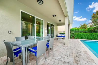 a patio with a table and chairs next to a swimming pool at Spacious Home With Private Pool And Game Room Near Disney With Waterpark Access At Encore Resorts Reunion - 390La in Orlando
