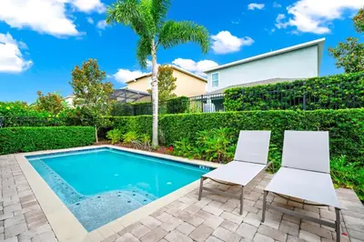 a swimming pool with two chairs and a house at Spacious Home With Private Pool And Game Room Near Disney With Waterpark Access At Encore Resorts Reunion - 390La in Orlando