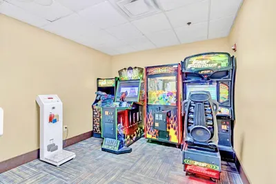 a room with three arcade games and a wii at Studio with Hot Tub & Pool Near Universal Studios in Orlando