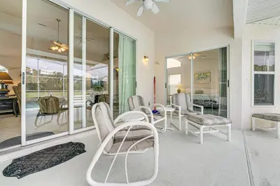 a room with chairs and a table and windows at 12 Mi to Disney Secluded Family Home with Pool in Kissimmee