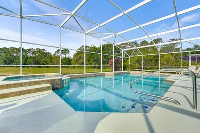 an indoor swimming pool with a large glass building at 12 Mi to Disney Secluded Family Home with Pool in Kissimmee