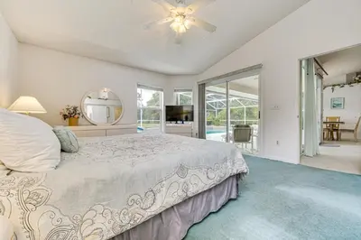 a bedroom with a bed and a ceiling fan at 12 Mi to Disney Secluded Family Home with Pool in Kissimmee