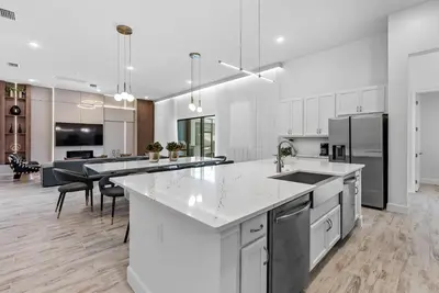 a large kitchen with white cabinets and a kitchen island at Brand NEW 11 Bedrooms At Sonoma in Kissimmee