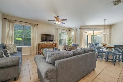 a living room with couches and a ceiling fan at The Hearth Home - 4 Suites in Kissimmee