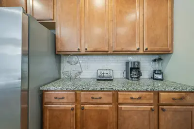 a kitchen with wooden cabinets and a counter top at The Hearth Home - 4 Suites in Kissimmee