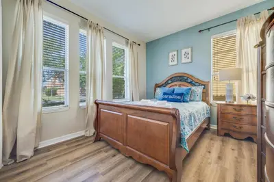 a bedroom with a bed with blue walls and windows at The Hearth Home - 4 Suites in Kissimmee