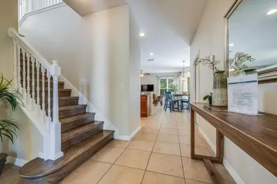a hallway with stairs and a dining room at The Hearth Home - 4 Suites in Kissimmee