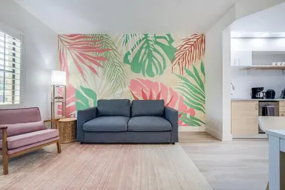 a living room with a blue couch and a colorful wall at Brand new - near Epic Universe & Universal Studios in Orlando