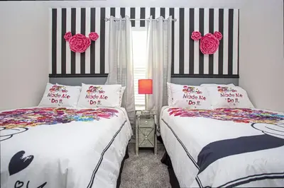 a bedroom with two beds and a window with pink roses at 5BR Private Pool Resort Amenities Near Disney in Kissimmee