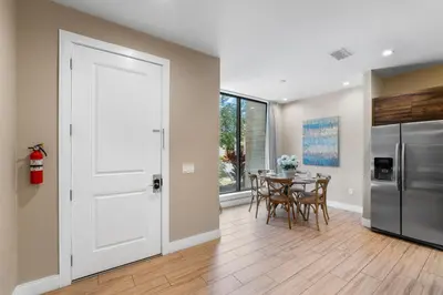 a kitchen and dining room with a table and a refrigerator at Magic Getaway 4 En-suites, BBQ & Near Parks in Orlando