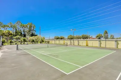 a tennis court with two tennis rackets on it at The Palms 1st floor By Pool, Fully Stocked 5 stars in Kissimmee