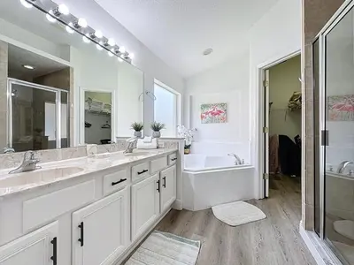 a bathroom with two sinks and a tub and a shower at Terra Verde Resort 4 Bed Pool Spa Villa villa in Kissimmee