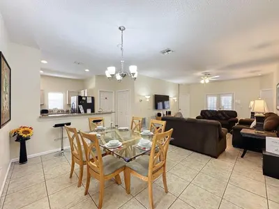 a dining room and living room with a table and chairs at Walk to Silver Spurs Rodeo and Heritage Park home in Kissimmee
