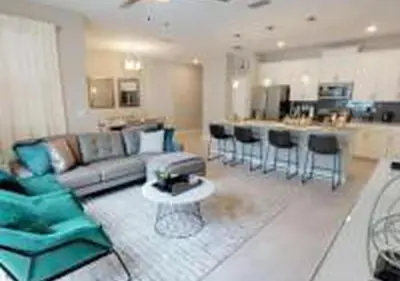 a living room with a couch and chairs and a kitchen at 4826 LL - Storey Lake Dream 4BR Pool Home Near Disney in Kissimmee