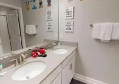 a bathroom with two sinks and a large mirror at 4826 LL - Storey Lake Dream 4BR Pool Home Near Disney in Kissimmee