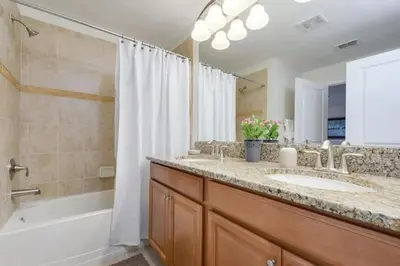 a bathroom with two sinks and a shower and a tub at 4815 Townhome com Piscina Privada– Storey Lake in Kissimmee