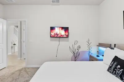 a white bedroom with a bed and a tv on the wall at Brand New 05 Bedrooms At Windsor Cay in Orlando