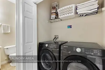 a laundry room with a washing machine and a shelf at Charming 3-Bedroom Home in Gated Oakwater Resort in Orlando