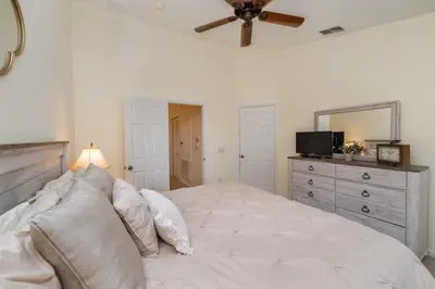 a bedroom with a large bed with a ceiling fan at MSW2505 Windsor Hills 3 Bedroom Private Pool Townhome in Orlando