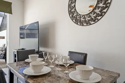 a table with plates and glasses and a mirror at OP7678 Windsor Hills 3 Bedroom Private Pool Townhome in Orlando