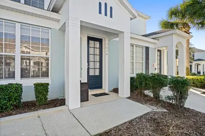 a house with a blue door and a sidewalk at OP7678 Windsor Hills 3 Bedroom Private Pool Townhome in Orlando