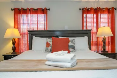 a bedroom with a bed with two lamps and towels at Storey Lake 4 BR with private pool in Kissimmee