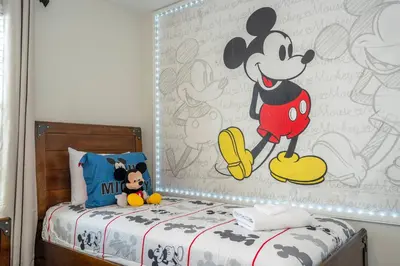 a bedroom with a mickey mouse mural on the wall at Storey Lake 4 BR with private pool in Kissimmee