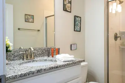 a bathroom with a sink and a mirror at Storey Lake 4 BR with private pool in Kissimmee