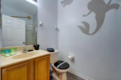 a bathroom with a sink and a toilet and a mirror at Disney Family Fun at Regal Oaks in Orlando