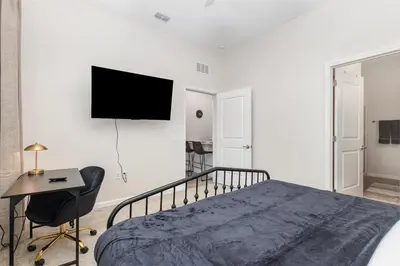 a bedroom with a bed and a desk and a television at Orlando 2BR Mins to Universal and More in Orlando