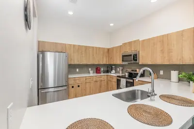 a kitchen with wooden cabinets and a stainless steel refrigerator at Orlando 2BR Mins to Universal and More in Orlando