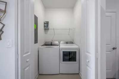 a small white kitchen with a stove in a room at Casa 5Q c/ Piscina e Temas Disney — Storey Lake in Kissimmee