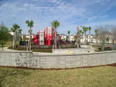 a playground in a park with a red play structure at Windsor Castle in Orlando