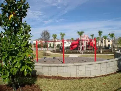 a playground in a park with a red play structure at Windsor Castle in Orlando