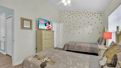 a bedroom with two beds and a tv on the wall at SKC7679 Windsor Hills Resort Vacation Townhome in Orlando