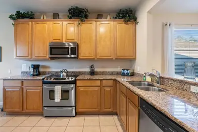 a kitchen with wooden cabinets and stainless steel appliances at PW2605 Windsor Hills Resort Vacation Home in Orlando