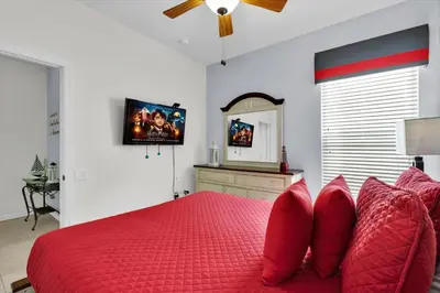 a bedroom with a red bed with red pillows and a mirror at MNL2702 Windsor Hills Resort Vacation Home in Orlando