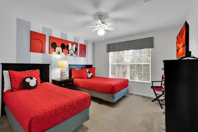 a bedroom with two beds with red sheets and a fan at MNL2702 Windsor Hills Resort Vacation Home in Orlando