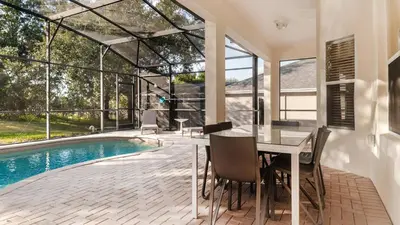 a dining room with a table and a swimming pool at MNL2696 Windsor Hills Resort Vacation Home - includes resort clubhouse amenity access in Orlando