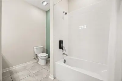 a white bathroom with a toilet and a bath tub at 3 Bedrooms 2 Bathrooms Storey Lake 3131-406 in Kissimmee