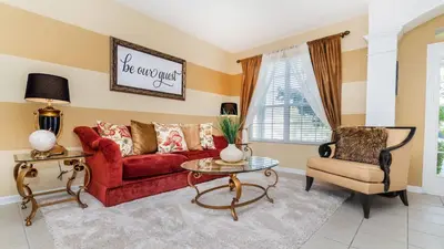 a living room with a red couch and a chair at MNL2696 - Windsor Hills Resort Vacation Home - includes resort clubhouse amenity access in Orlando
