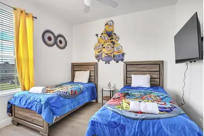a bedroom with two beds and a flat screen tv at Windsor Palms Resort in Kissimmee