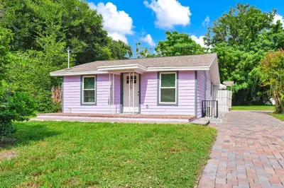 a pink house with a brick driveway at Cozy 2bd 2bth House Walk to Local Gems in Orlando
